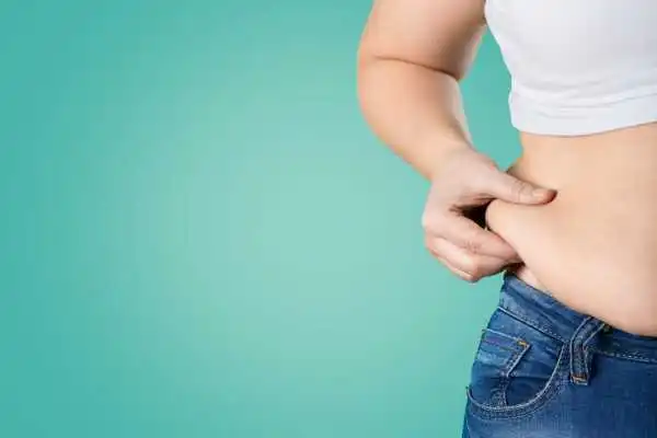 Image of woman pinching her love handles to show weight gain Amersham